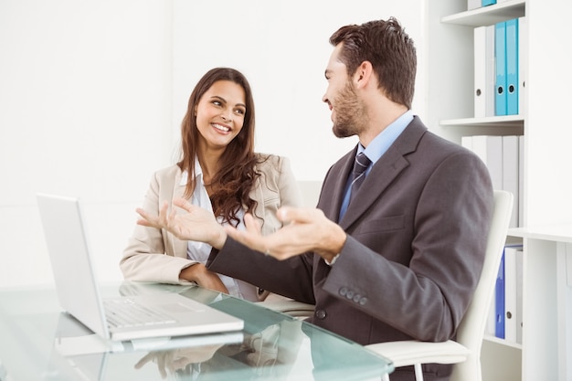 Business people using laptop in office