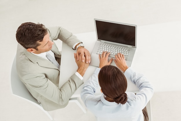 Business people using laptop in office