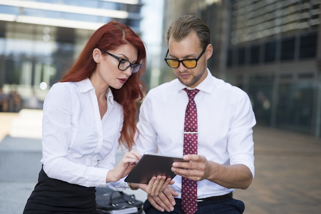 Business people using a tablet outdoors