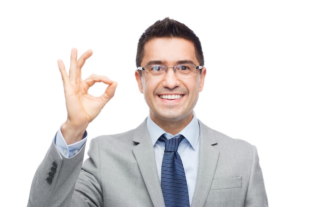 business, people, vision and office concept - happy smiling businessman in eyeglasses and suit