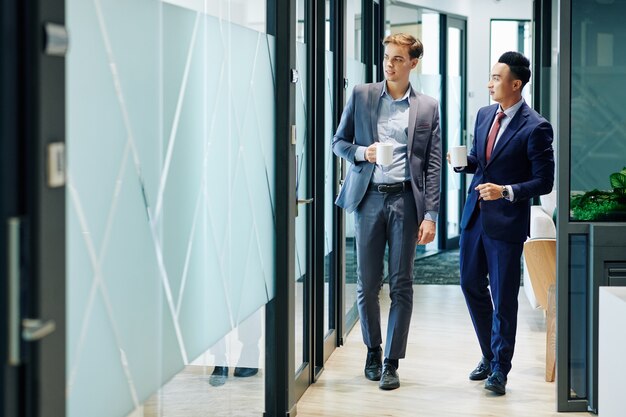 Business people walking along office corridor