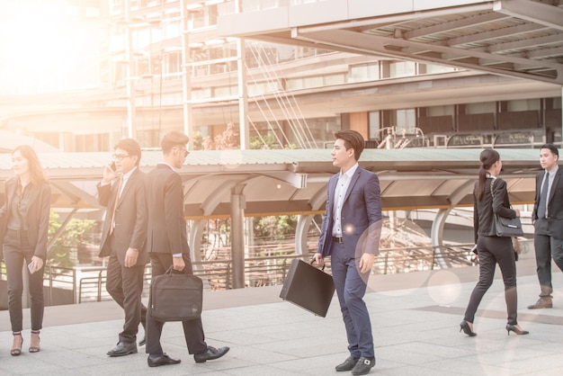 business people walking on sidewalk in city