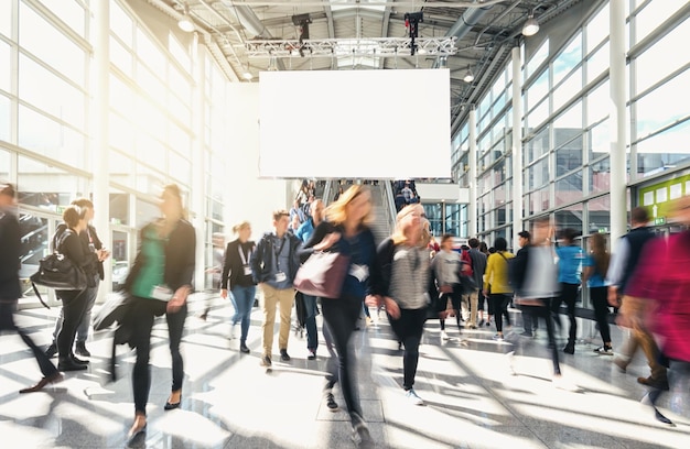 business people walking at a tradeshow including banner for copy space . ideal for websites and magazines layouts