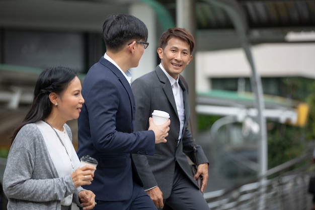 business people walking to work in the morning hand holding coffee cup