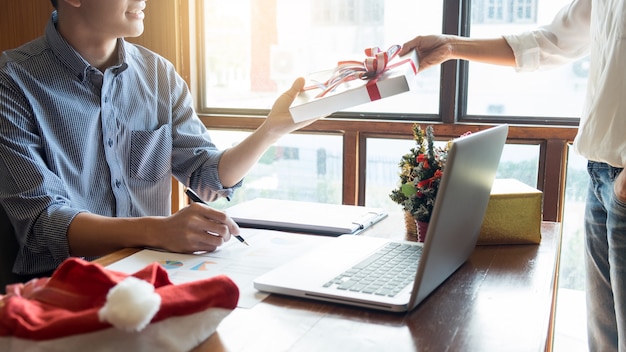 Business people wearing Santa hat  celebrating 2019 New Year Christmas presents at office 