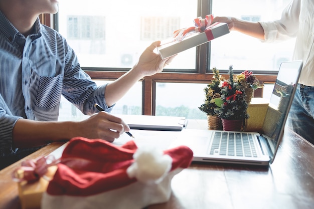 Business people wearing Santa hat  celebrating 2019 New Year Christmas presents at office 