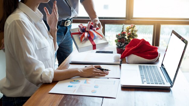 Business people wearing Santa hat  celebrating 2019 New Year Christmas presents at office 