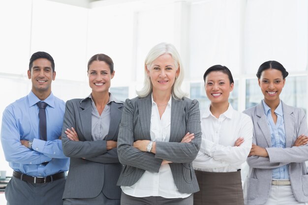 Business people with arms crossed smiling at camera 