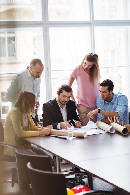 Business people with blueprint in meeting room