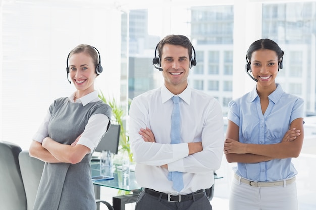 Business people with headsets smiling at camera 