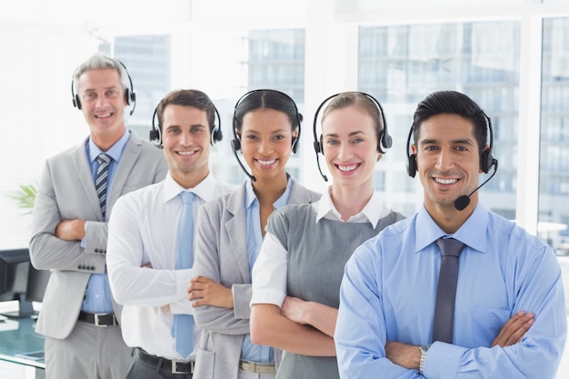 Business people with headsets smiling at camera 