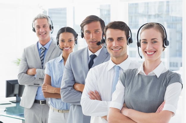 Business people with headsets smiling at camera 