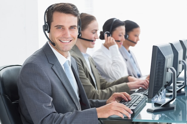 Business people with headsets using computers in office