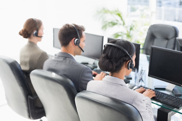 Business people with headsets using computers