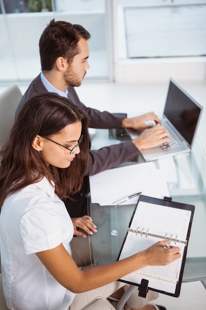 Business people with laptop and diary at office