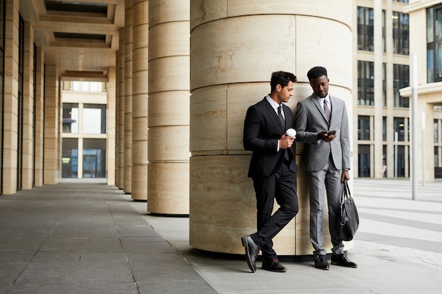 Business people with mobile phone outdoors