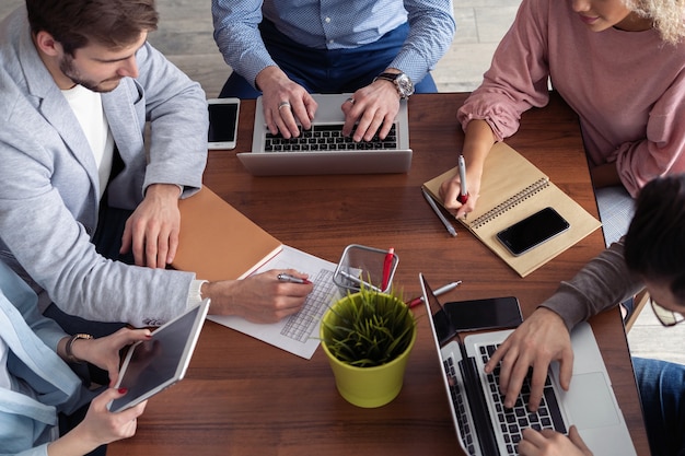 Business people working and communicating while sitting at the office desk together