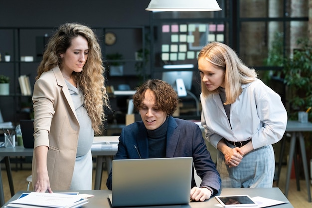 Business people working on laptop in team