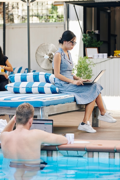 Business people working at lounge area with swimming pool