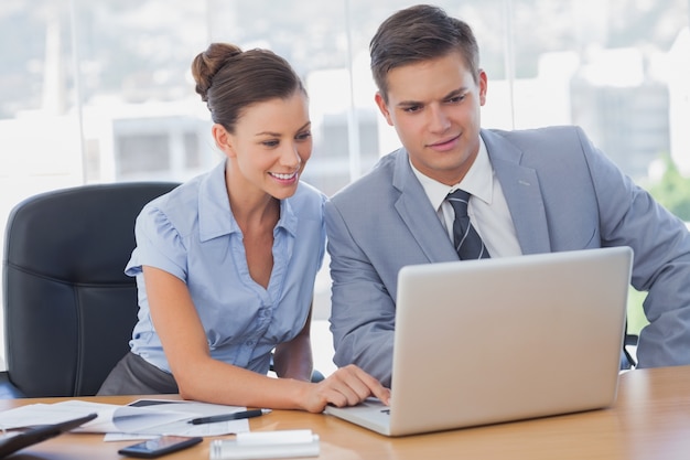 Business people working together on laptop and smiling 