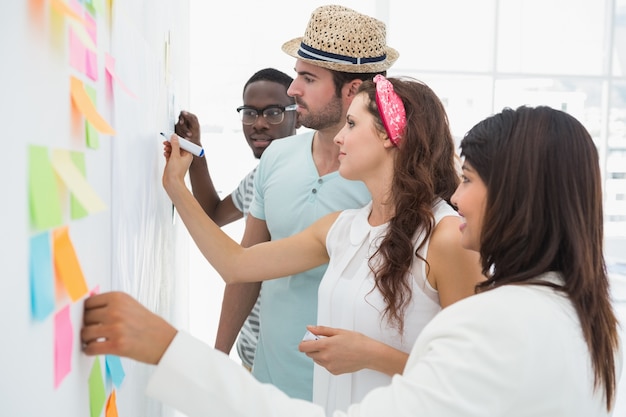 Business people writing ideas on sticky notes