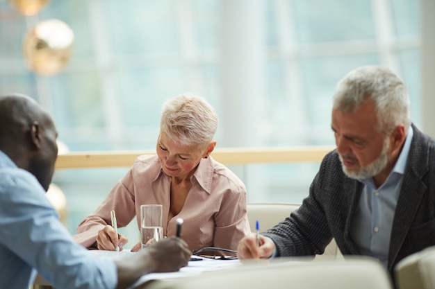 Business People Writing in Meeting