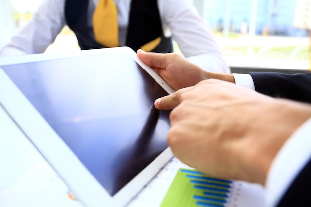 Business person analyzing financial statistics displayed on the tablet screen