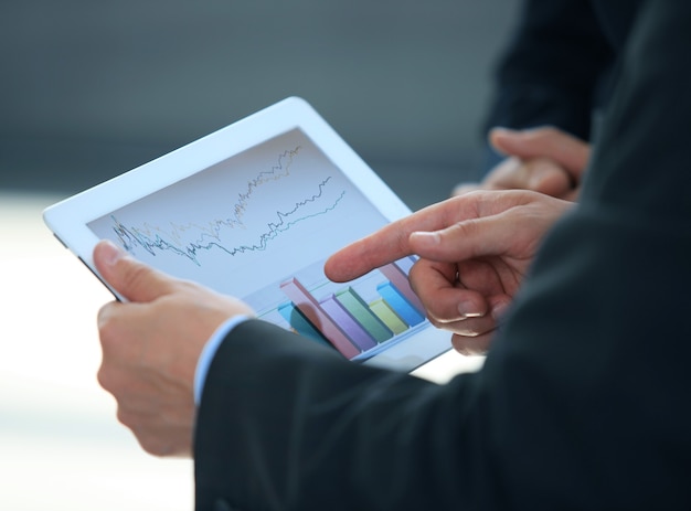 business person analyzing financial statistics displayed on the tablet screen