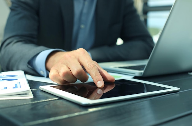 Business person analyzing financial statistics displayed on the tablet screen