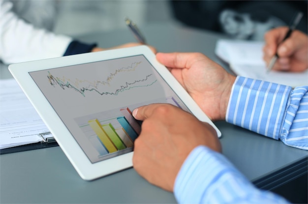 business person analyzing financial statistics displayed on the tablet screen