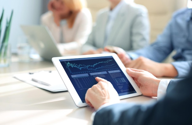 Business person analyzing financial statistics displayed on the tablet screen