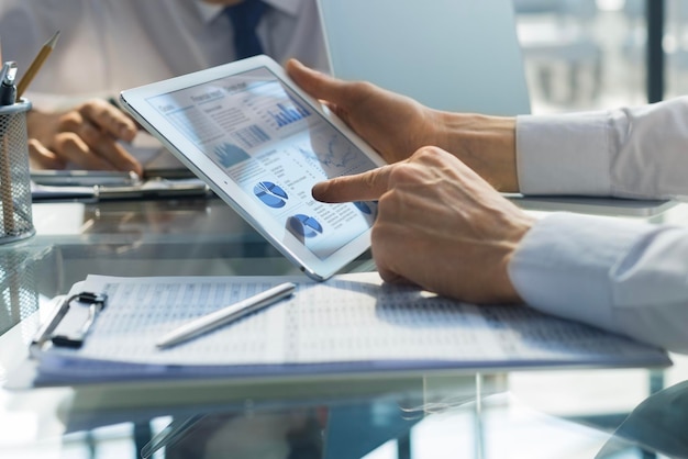 Business person analyzing financial statistics displayed on the tablet screen