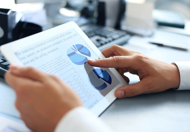 Business person analyzing financial statistics displayed on the tablet screen