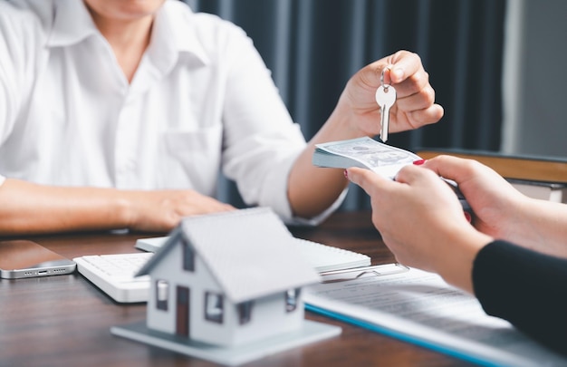 Business person hands holding home model small building red\
house real estate agents offer contracts to purchase or rent\
residential mortgage property insurance moving home and real estate\
concept