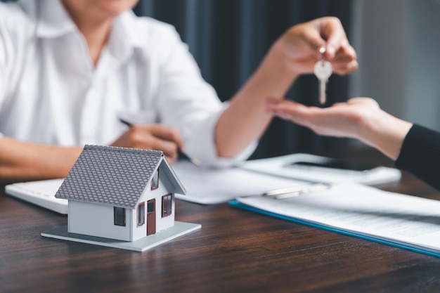 Business person hands holding home model small building red\
house real estate agents offer contracts to purchase or rent\
residential mortgage property insurance moving home and real estate\
concept