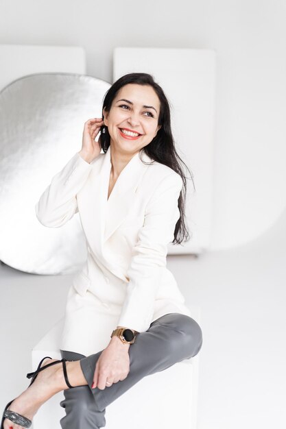 The business person is in a good mood A beautiful happy brunette woman in a white jacket laughs