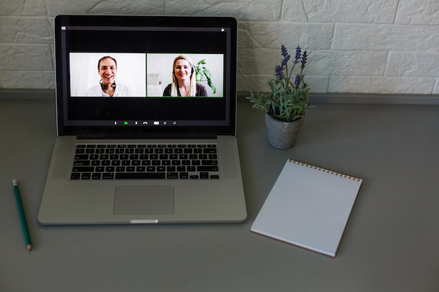 Business Person Videoconferencing With Colleagues On Laptop