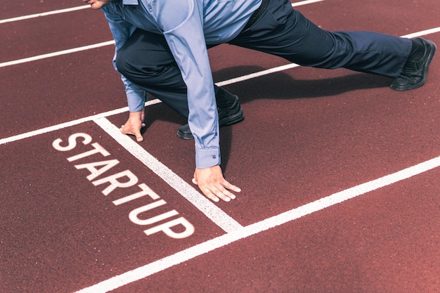 Business person waiting for start signal to run on the\
competition running track startup business co