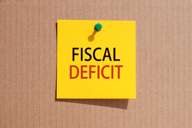 Business phrase - fiscal deficit - written on yellow square paper and pinned on paperboard, concept