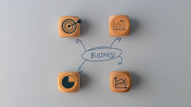 Photo business plan idea sketches with business icons on wooden cubes over a grey background business planning concept