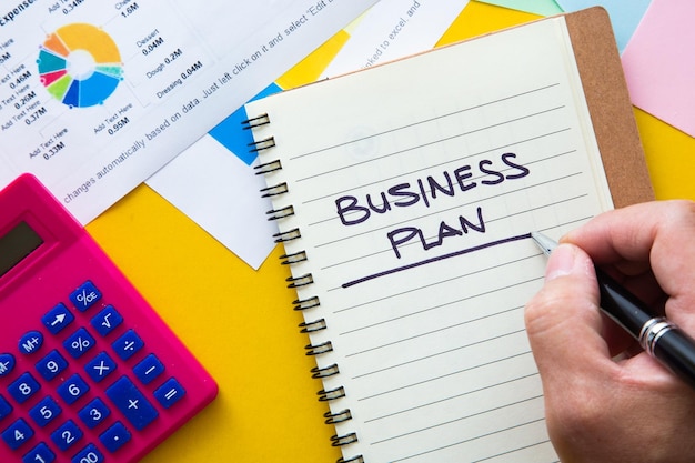business plan written on notepad with graph analysis background business plan concept