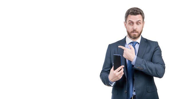 Business professional man in formal suit hold mobile phone pointing finger for copy space isolated on white advertising