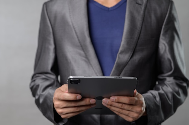 business professional in suit holding tablet device in modern setting