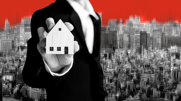 Photo business realtor man holding home model for investment on city background in black and white theme color