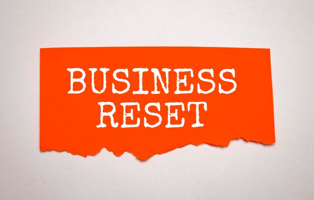 Business reset words on the red torn paper