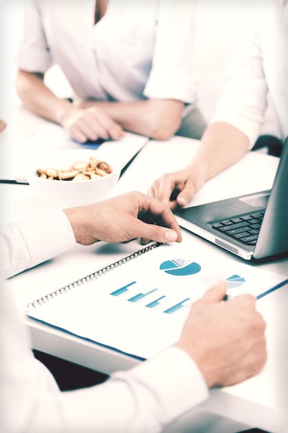 Concetto di business, scuola e istruzione - team aziendale amichevole che discute in ufficio