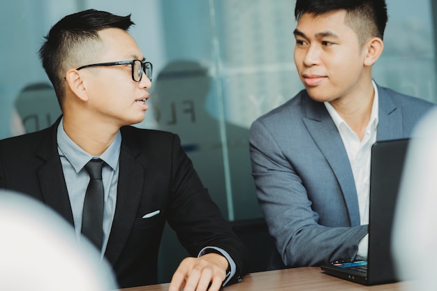 Business staff discuss with colleagues nearby during the meeting