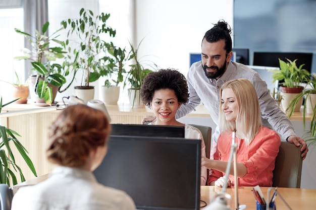 business, startup and people concept - happy creative team networking with computer in office