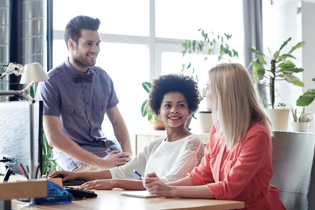 Photo business, startup and people concept - happy creative team talking in office