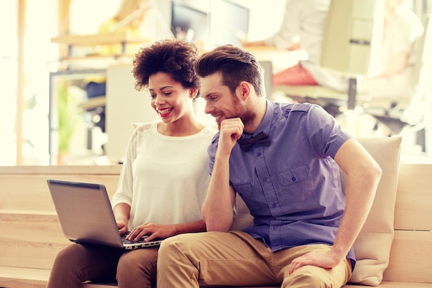 Photo business, startup and people concept - happy creative team with laptop computer in office